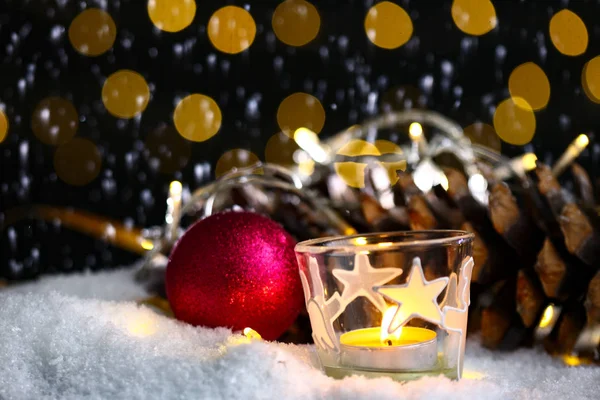 Tema de Natal com velas, neve, cone de pinho e luz de Natal — Fotografia de Stock