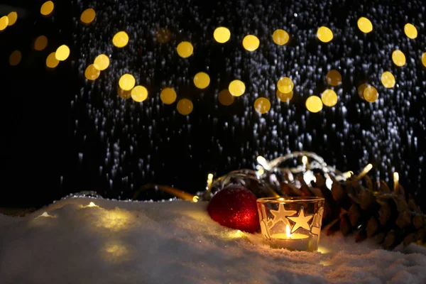 Tema de Natal com velas, neve, cone de pinho e luz de Natal — Fotografia de Stock