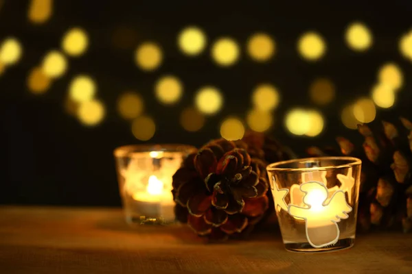 Christmas theme with candles, snow, pine cone and christmas light — Stock Photo, Image