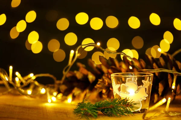Tema de Navidad con velas, nieve, cono de pino y luz de Navidad — Foto de Stock