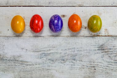 Ahşap zemin üzerinde fotokopi alanı olan renkli paskalya yumurtası