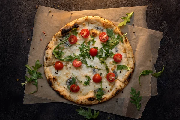 Kağıt ve koyu ahşap zemin üzerine domates peynir pizza — Stok fotoğraf