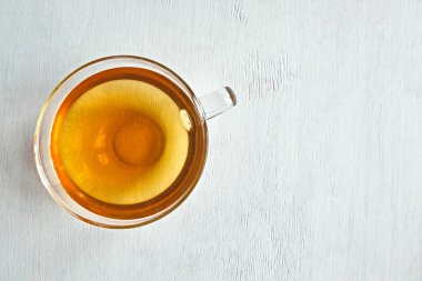 Bir bardak yeşil tıbbi çay. Beyaz ahşap arka plan. Yukarıdan manzara. Uzayı kopyala Yatay