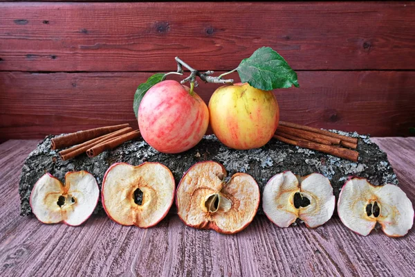 Organic Apple chips (slices) on a wooden background, next to fresh fruit.Dried Apple slices are a healthy vegetarian fruit snack or cooking ingredient. The concept is a healthy diet.