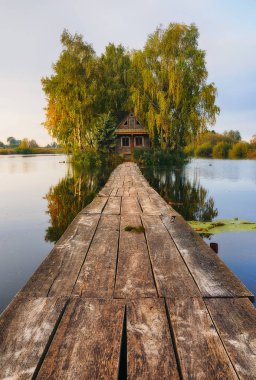 Adadaki bir ev. Küçük bir adadaki bir kulübeye köprü