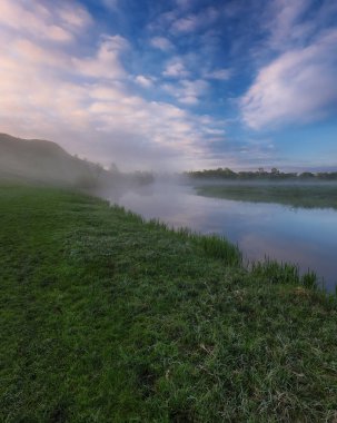 Nehir vadisinde sis var. resim gibi bir bahar sabahı. Güzel sisli gün doğumu sisli bir çayırda