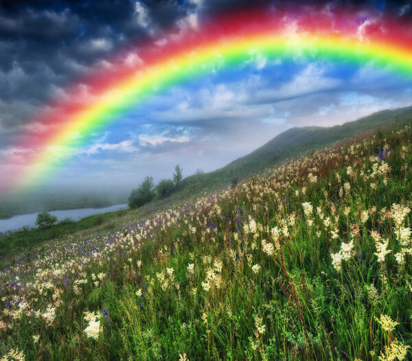 rainbow over the river. picturesque spring meadow. before the storm