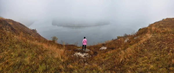 tourist over the fog. morning fog in the canyon of the river. woman enjoys a beautiful view