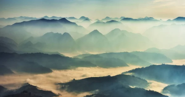 霧の多い山のシルエット 日の出の絵になる山の峰 — ストック写真