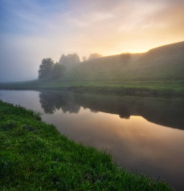 Suda yansıma. Pahalı bir nehrin vadisinde şafak vakti. bahar sabahı