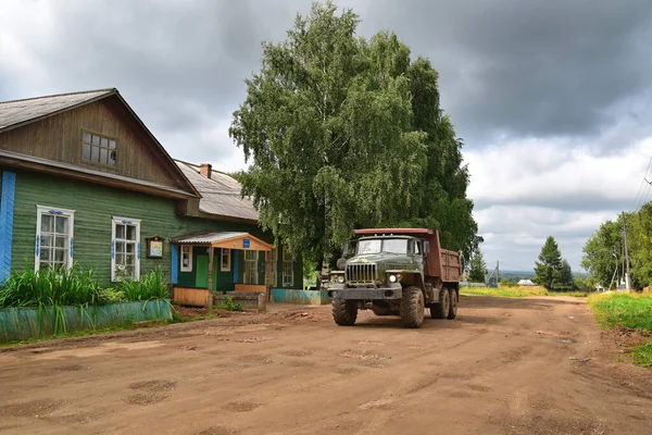 Sıcak yaz güneşinin altında bir Rus köyü. Eski ahşap evler, tarlalar ve bakırlar.