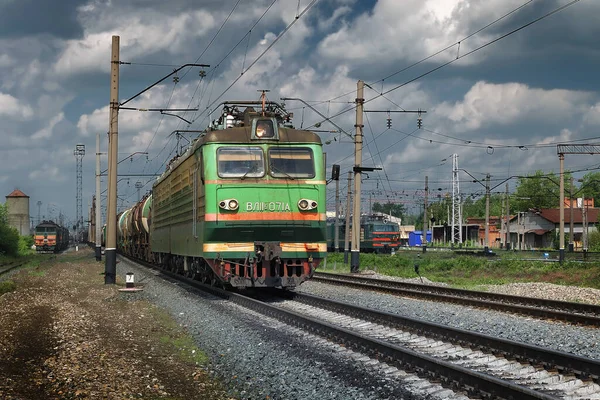 Een elektrische locomotief met een goederentrein beweegt langs de rails van de spoorweg — Stockfoto