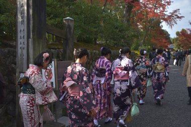Tipik giysiler içindeki Japonlar Kinkakuji tapınağını ziyaret ederler.