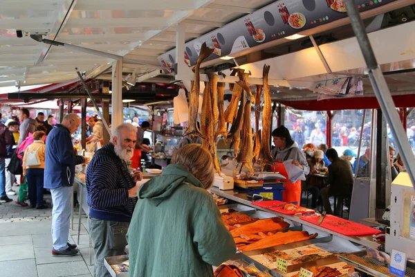 卑尔根鱼类市场上向客户出售海产食品的人 — 图库照片