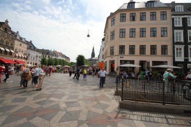 Kopenhag 'ın göbeğindeki Amagertorv alışveriş bölgesindeki Leylek Çeşmesi' nin etrafındaki sokakta gün ışığının tadını çıkaran müşteriler ve turistler.