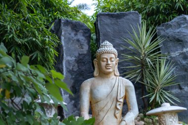 Buda heykeli. Arka planda güzel kayalar var.