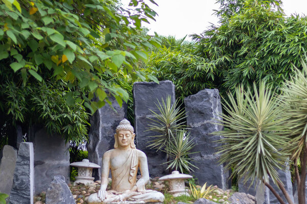 Low angle wide shot of a buddha statue in meditation pose.