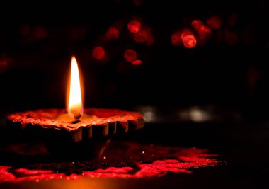 Yerde rangoli olan bir terracotta lambasının yüksek açılı görüntüsü.