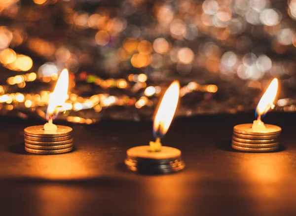 stock image Three burning candles on pile of coins and beautiful bokeh for D