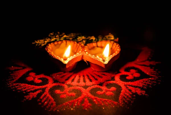 Diwali C 'de iki parıldayan terracotta lambası koyu arka planda
