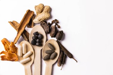 Üç tahta kaşıkta Ayurvedic ilaçlar. Beyaz arka planda ve kopyalama alanında bütün baharatlar var. Alternatif ve Unani tıp konsepti