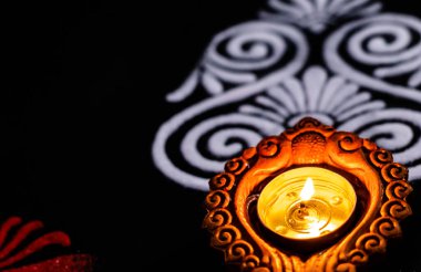 Güzel, parıldayan kil lambayı, kırmızı beyaz ve rangoli sanatını fotokopi alanı ile kapatıyoruz. Işık festivali konsepti