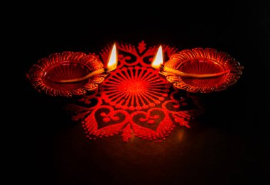 İki parlayan terracotta lambası iki terracotta lambası, Deepawali konseptinde ön manzara ve siyah arka planda güzel rangoli sanatı. Işık festivali, karanlık arka plana karşı rangoli kavramı. diwali concpet