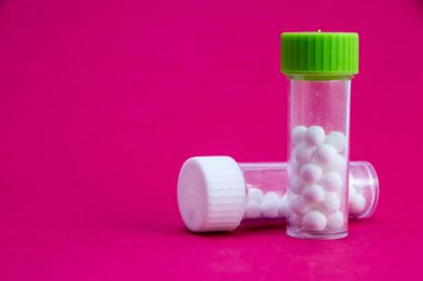 Atomik Mandalina sırtı. Vitaminler (uyuşturucular) açık beyaz cam bir kavanozun (kap) yanına saçılmış ve dökülmüştür. İlaçlar ve ilaçlarla tedavi.