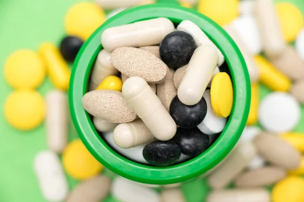 Monte Comprimidos Dentro Fora Recipiente Medicamento Fundo Verde — Fotografia de Stock