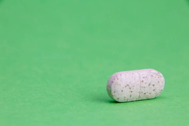 Tıbbi hap tableti yeşil arka planda izole edilmiş, kırpma yolu dahil. İlaç ve eczane kavramı