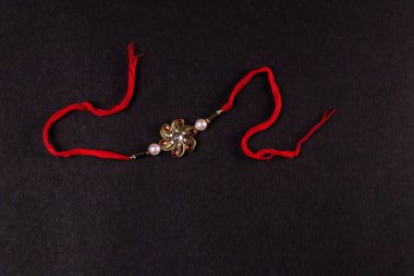 Hint festivali - Zarif Rakhi karanlık yüzeyde izole edildi. Geleneksel Hint bilekliği Kardeşler ve Kız Kardeşler arasındaki aşkın sembolüdür.
