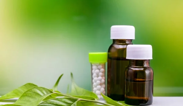 Zbliżenie Strzał Bursztynowych Szklanych Butelek Homeopathy Leków Zielonym Tle Niewyraźne — Zdjęcie stockowe