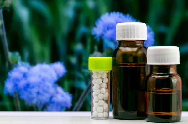 Close Shot Homeopathic Pills Liquid Glass Bottles Blurred Blue Flowers — Stock Photo, Image