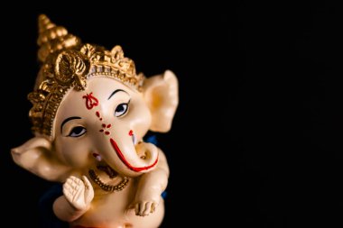 Yüksek açılı, siyah arkaplanlı ve fotokopi alanı olan muhteşem Ganesha heykelinin yakın plan çekimi. dini kavramlar