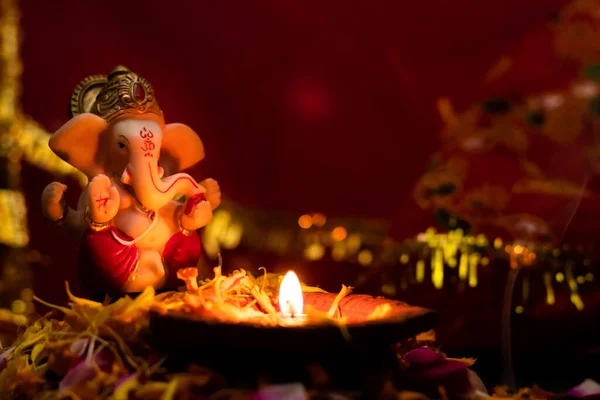 Ziemna Lampa Płatkach Róż Posągiem Ganesha Rozmytym Czerwonym Złotym Tle — Zdjęcie stockowe
