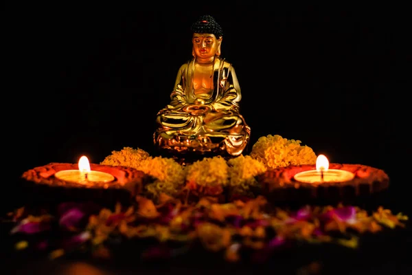 Zwei Verschwommene Tonlampen Auf Rosenblättern Vor Buddha Statue Vor Schwarzem — Stockfoto