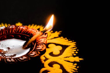 Flaman manzaralı toprak lambası alev tarımcı siyah arka planla akıyor. diwali konsepti