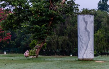 Arka planda ağaçlar olan geniş desenli mermer taş yapı. Uyum kavramı