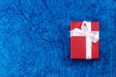 Kırmızı bir düğün hediyesi kutusunun üst kısmı mavi kağıtta, dokulu yüzeyi var. Sevgililer Günü hediyesi konsepti