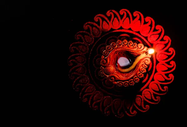 Fotokopi uzayı olan rangoli tasarımında karanlıkta parlayan güzel bir terracotta lambası. Işık festivali konsepti