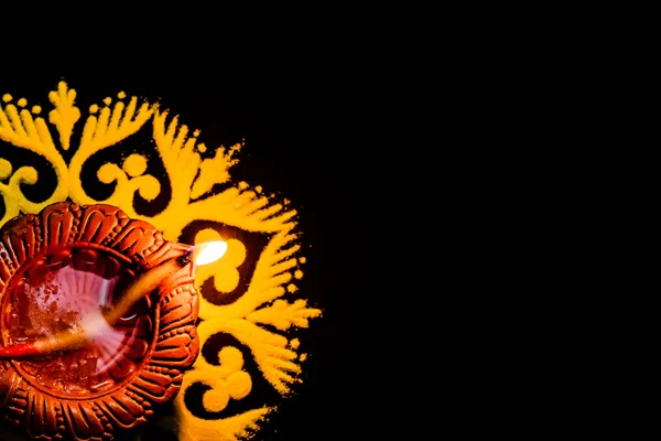 Fotokopi uzayı olan rangoli tasarımında karanlıkta parlayan güzel bir terracotta lambası. Işık festivali konsepti