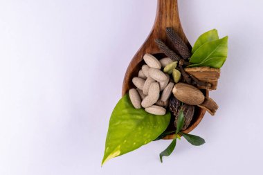 Alternatif tıp konsepti. Ayurvedik ilaçlar ve beyaz arka planda tahta kaşıkta farklı baharatlar.