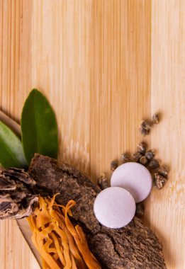 Ahşap arka planda yeşil yapraklı beyaz bitkisel ilaçlar ve baharatlar. Doğal tedavi kavramı