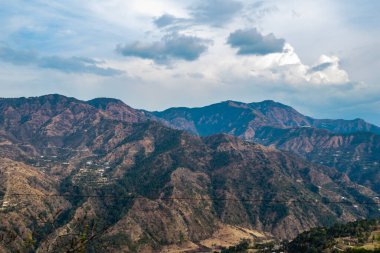  Arka planda dağların dramatik fotoğrafları ve bulutlu mavi gökyüzü