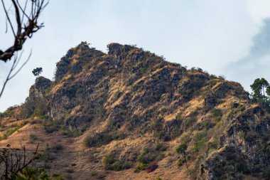 Güneş ışığı dağa düşüyor ve arka planda bulutlu gökyüzü, doğa konsepti.