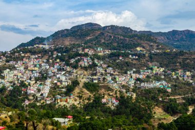 Dağlardaki güzel şehir manzarası bulutlu mavi gökyüzünün altında.