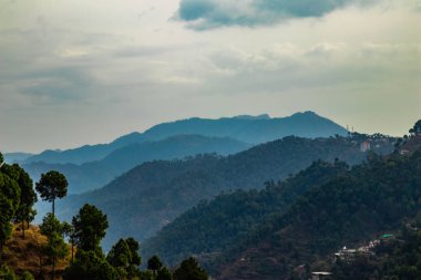 Bulutlu gökyüzünün altında güzel dağların geniş bir görüntüsü, güzellik konsepti.