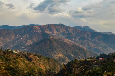 Vadileri ve arka planında bulutlu gökyüzü olan güzel dağların geniş bir görüntüsü, doğa kavramı.