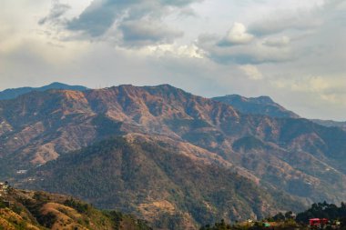 Geniş bir dağ manzarası ve arka planda bulutlu bir gökyüzü, güzellik konsepti