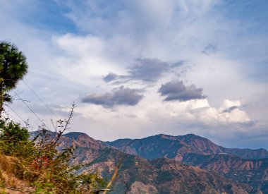 Bulutlu mavi gökyüzünün altındaki dağların dramatik fotoğrafçılığı, doğa güzelliği kavramı